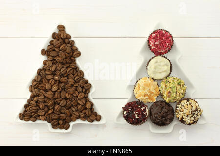 Deux lave-sapins avec les grains de café torréfiés et chocolats sur l'ensemble de fond en bois blanc Banque D'Images