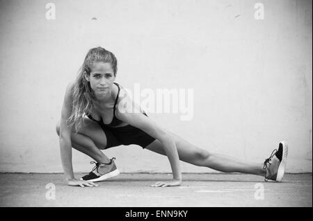 Modèle de remise en forme Maria Ambrose étend sa jambe sur un terrain de handball à Brooklyn, New York. Banque D'Images