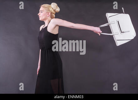 Jeune femme blonde fougueuse avec sac à main Banque D'Images