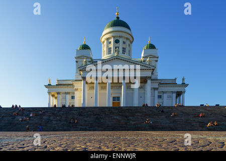 Les gens assis sur les marches d'une soirée ensoleillée à l'extérieur de la cathédrale d'Helsinki, Finlande. Banque D'Images