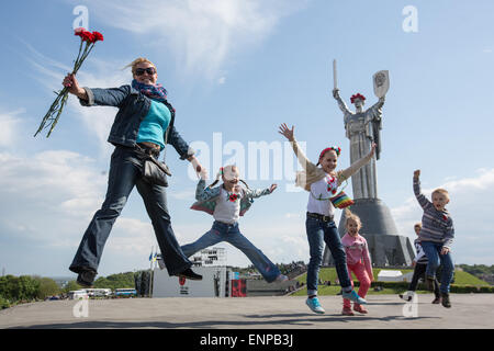 Kiev, Ukraine. 09 mai, 2015. Une femme passe avec sa fille et ses amis en face de la 'Mothersland Rodina-Mat" (mère) monument à Kiev, Ukraine, 09 mai 2015. Photo : Jan A. Nicolas/DPA - PAS DE FIL - SERVICE/dpa/Alamy Live News Banque D'Images