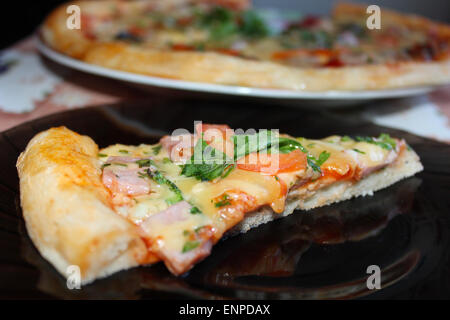 Morceau de pizza savoureuse avec un appétissant farce sur la plaque Banque D'Images