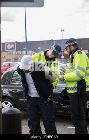 Un contre-manifestant est arrêté après avoir confronté partisans de la Ligue de défense anglaise dans un parking local. Banque D'Images