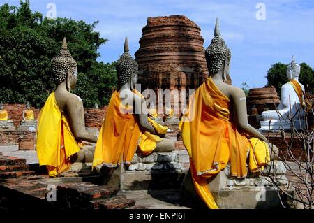 Ayutthaya, Thaïlande : Lignes ofseated les statues de Bouddha drapés dans l'orange et à la robe safran galerie du cloître Banque D'Images