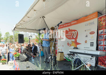 Toronto, Canada. 9e mai 2015. Défenseur des anciens combattants militaires/Delgado-Levin-Jonathan Turner parle de la participation canadienne à la seconde guerre mondiale pour la partie officielle de cérémonie pour 70 ans anniversaire du Jour de la Victoire (1945-2015). Il est traduit en russe par jeune homme en uniforme militaire soviétique. Fête de la victoire marque la capitulation de l'Allemagne nazie à l'Union soviétique dans le cadre de la Seconde Guerre mondiale. Crédit : Igor Ilyutkin/Alamy Live News Banque D'Images