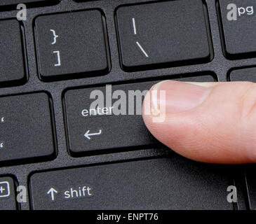 Entrée de l'ordinateur avec le doigt appui bouton sur le fond blanc Banque D'Images