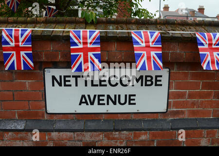 Drapeaux Union Jack accroché sur un mur au-dessus d'une plaque de rue en Angleterre. Banque D'Images