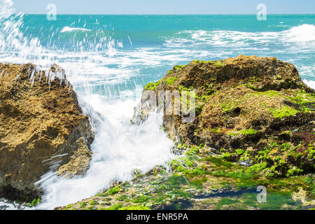 Rolling wave Turquoise claquant sur les rochers de la côte Banque D'Images