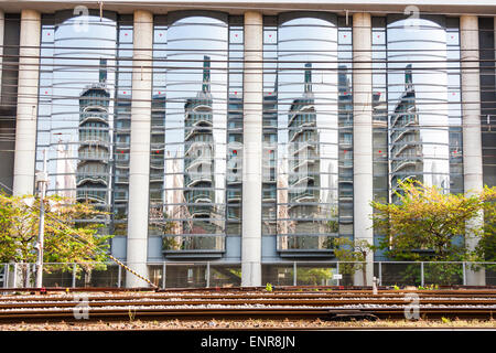 Kyoto. Façade de bureau en verre très réfléchissante reflétant un autre immeuble de bureaux de l'autre côté des voies ferrées entre les deux. Banque D'Images