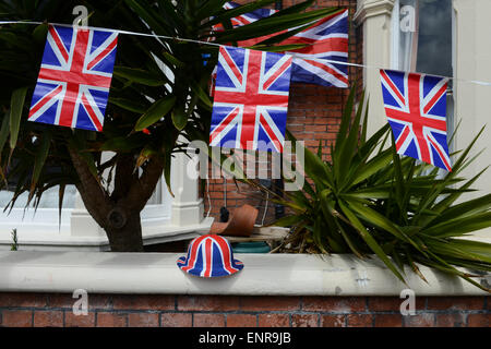 Union Jack Bunting, drapeaux et d'un Union Jack hat sur un mur de jardin lors d'une fête de rue à Southsea, Hampshire, Angleterre pour célébrer le 70e anniversaire du Jour de la victoire.​ Banque D'Images