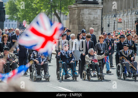 Bon nombre d'anciens combattants sont en fauteuil roulant poussé par de personnel des forces armées et des services d'urgence. Jour de la VICTOIRE 70 - Marquage des commémorations anniversaire historique de la fin de la Seconde Guerre mondiale en Europe. après un service d'action de grâce à l'abbaye de Westminster, un défilé des anciens combattants et le personnel de service, dirigé par un pipe band militaire, et un défilé aérien - Vers le bas et en whitehall Horse Guards Parade. Banque D'Images