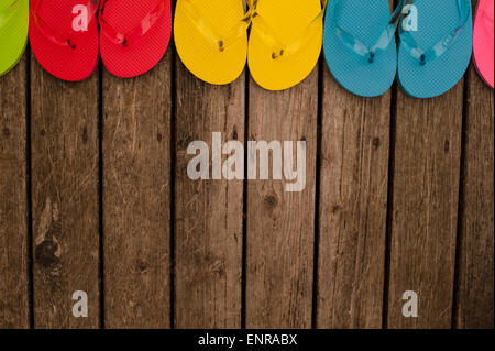 Tongs multicolores sur terrasse en bois Banque D'Images