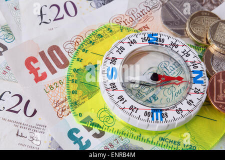 Boussole sur les billets en livre sterling pour illustrer l'orientation du concept de reprise économique britannique et de l'austérité. Angleterre, Royaume-Uni, Grande-Bretagne Banque D'Images
