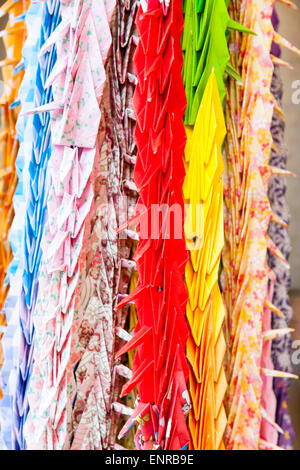 Temple Kiyoshikōjin Seichō-ji à Takarazuka au Japon. Rangées de grues en papier de différentes couleurs suspendues à partir d'un cadre en bois disposées principalement par couleur. Banque D'Images