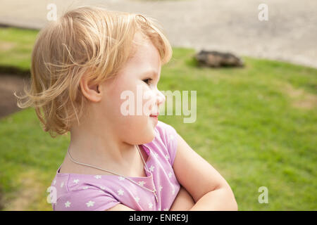 Outdoor portrait of cute smiling Caucasian baby girl blonde dans un parc Banque D'Images