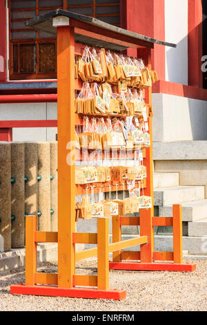Tableaux ema japonais, tablettes de souhaits, suspendus à des cadres de travail à un sanctuaire Shinto. Les espoirs, les souhaits et les dédicaces sont écrits sur eux. Banque D'Images
