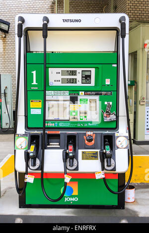 Pompe à essence en libre-service japonaise, gros plan des trois pompes, une pour le diesel et un bouton d'arrêt. Étiquettes pour carburant en jaune, rouge et vert. Banque D'Images