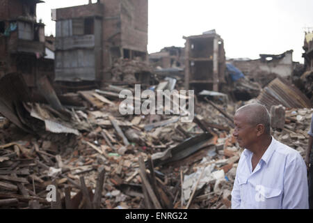 Vaktapur, Népal. 10 mai, 2015. Un homme se tient devant une maison effondrée dans Vaktapur le 10 mai 2015, près de Katmandou, Népal. Un important séisme a frappé 7,9 Népal à la mi-journée le samedi 25 avril, de nombreuses maisons, la construction et les temples dans la capitale ont été détruits pendant le séisme, laissant plus de 7000 morts et beaucoup plus coincés sous les débris comme les travailleurs de secours d'essayer d'enlever les débris et de retrouver des survivants. Credit : Suvra Kanti Das/ZUMA/ZUMAPRESS.com/Alamy fil Live News Banque D'Images