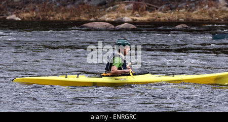 Senior mâle dans un kayak jaune. Kayak sur la rivière Hudson USA Nord Adirondack State Park Adirondacks. Banque D'Images