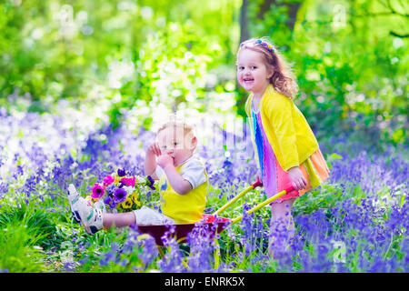 Jardinage pour les enfants. Les enfants jouent à l'extérieur. Petite fille et garçon, frère et soeur, travaillant dans le jardin, planter des fleurs Banque D'Images