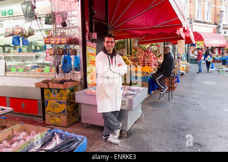 Deux commerçants à l'extérieur de leurs magasins d'alimentation traditionnels sur electric avenue, Brixton, Londres, Angleterre, Royaume-Uni Banque D'Images