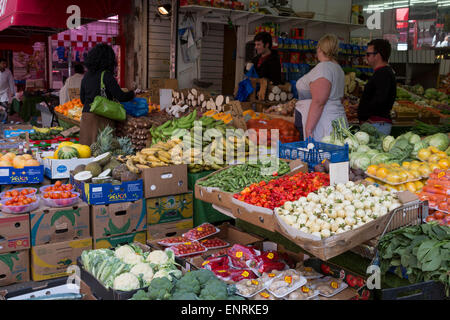 Légumes traditionnels avec des produits de fabrication sur l'affichage et les clients sur electric avenue, Brixton, Londres, Angleterre, Royaume-Uni Banque D'Images