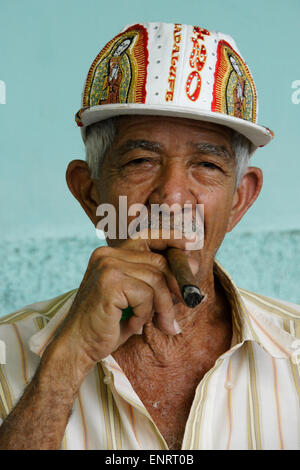 Un homme âgé dans fantaisie cap fumer un cigare, Pinar del Rio, Cuba Banque D'Images