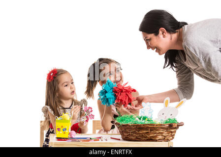 Mère parle avec sa fille qui la peinture des œufs de Pâques à table Banque D'Images