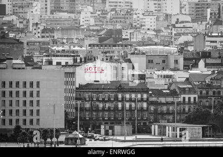 Maisons et immeubles de la ville de Vigo, Espagne, derrière le port, et panneau rouge "hôtel" sur fond monochrome Banque D'Images