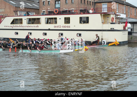 Gloucester, Royaume-Uni. 10 mai, 2015. Les équipes de la course de bateaux-dragons se rassemblent à Gloucester docks pour la 18e édition de la régate. L'événement a recueilli des fonds pour les organismes de bienfaisance pour aider les enfants et les jeunes atteints du cancer. Crédit : Chris Poole/Alamy Live News Banque D'Images