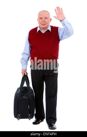Ancien senior man holding une valise et en agitant sa main, isolé sur fond blanc Banque D'Images