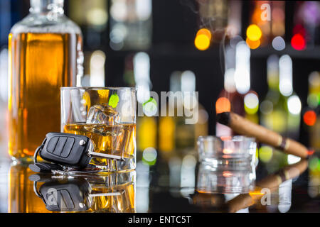 Verre de whisky avec des fumeurs de cigare et de clé de voiture sur le comptoir du bar. Notion de danger de l'alcool et la conduite automobile Banque D'Images