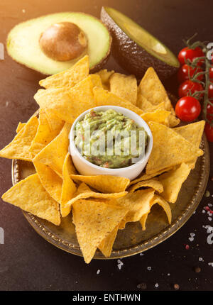 Guacamole vert avec des nachos et d'avocat sur fond de pierre Banque D'Images