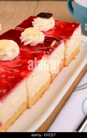 Quatre morceaux de gâteau framboise sur une plaque blanche Banque D'Images