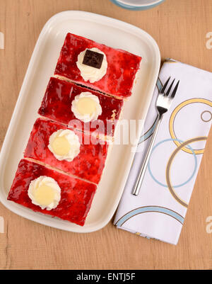 Quatre morceaux de gâteau framboise sur une plaque Banque D'Images