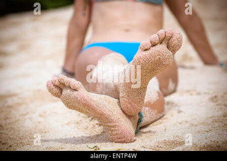 Pieds de la femme sur la plage de sable. Banque D'Images