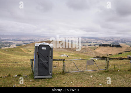 Toilettes portables sur la promenade à travers les terres agricoles pour le sommet du mont Cass, Canterbury, Nouvelle-Zélande. Banque D'Images