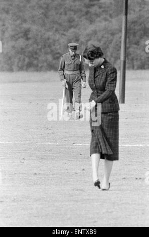 Horodatage de la reine Elizabeth II la terre sur un terrain de polo Brigades Ménage des matches de polo à Windsor Great Park spectateurs demandé pour aider à lisser la masse grumeleuse lors d'une pause dans le tournoi. Juin 1955 Banque D'Images