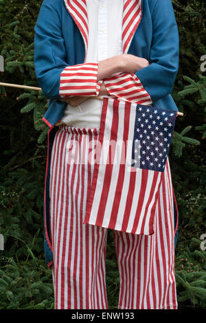 Résident local porte un costume de l'Oncle Sam alors qu'il montre le drapeau défilant dans une parade du 4 juillet dans la petite ville du Maine, USA. Banque D'Images