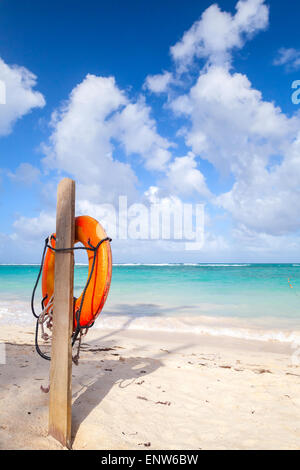 Bouée rouge accroché sur poteau en bois, plage de sable vide de la République Dominicaine Banque D'Images