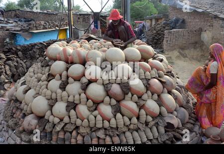 Allahabad, Inde. Le 11 mai, 2015. Un potter met la cruche en terre sur un Bhatti avant de vendre sur le marché. Pichet en terre est utilisé pour garder l'eau fraîche, elle est généralement utilisée dans le famille de la classe moyenne. © Prabhat Kumar Verma/Pacific Press/Alamy Live News Banque D'Images