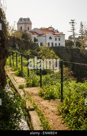 Canal d'irrigation et sentier Levada de Levada Nova, Ponta do Sol, à Madère. Laurisilva fôret subtropical. Lombada chapelle. Banque D'Images