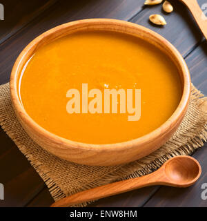 Soupe de potiron servi dans un bol en bois, photographié sur bois foncé avec lumière naturelle (Selective Focus) Banque D'Images