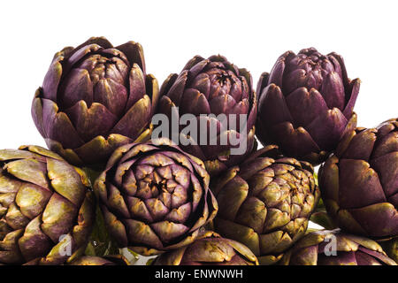 Pile d'artichauts violets et prête pour la cuisson, isolé Banque D'Images