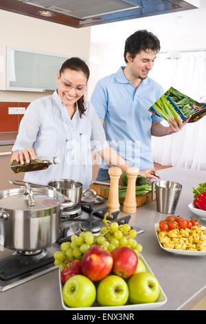 Jeune couple heureux cook en cuisine avec cookbook Banque D'Images