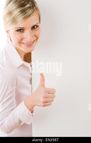 Happy businesswoman derrière la bannière vide Thumbs up Banque D'Images