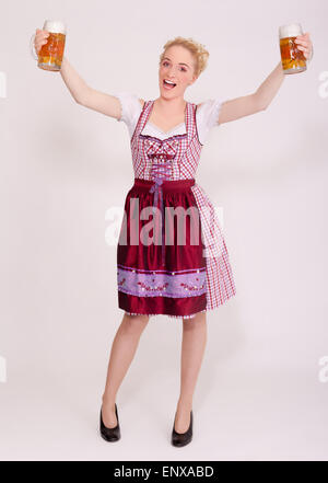 Jeune femme dans la dirndl plein de deux chopes de bière Banque D'Images