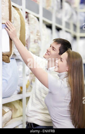 L'heureux couple choisit un oreiller dans le magasin Banque D'Images