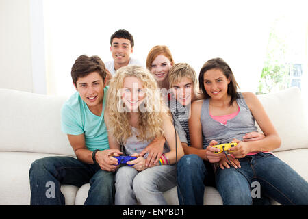 Adolescents jouant à des jeux vidéo dans le salon Banque D'Images