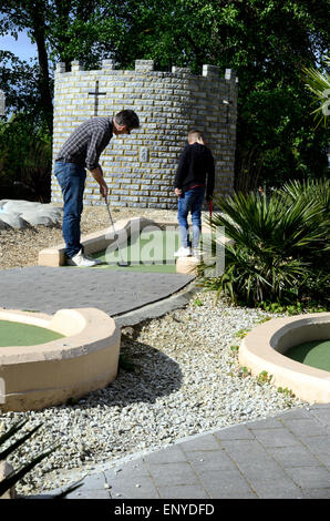 Un père et son fils, jouer mini golf à Windsor. Banque D'Images